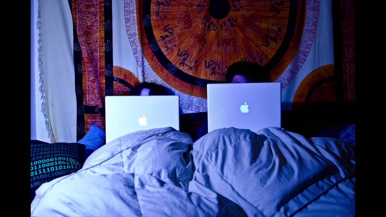 Человек в кровати с ноутбуком